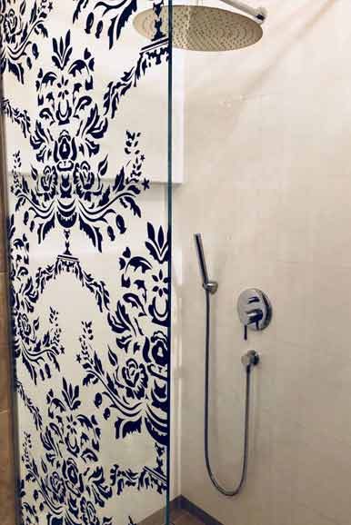 Dusche mit blau-weißer Ornamentwand