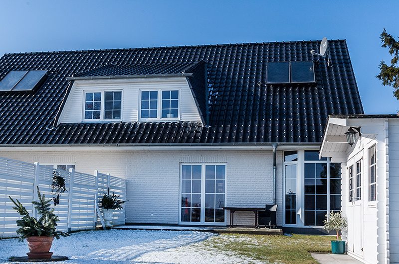 Doppelhaushälfte mit Gauben und Wintergarten im Schnee